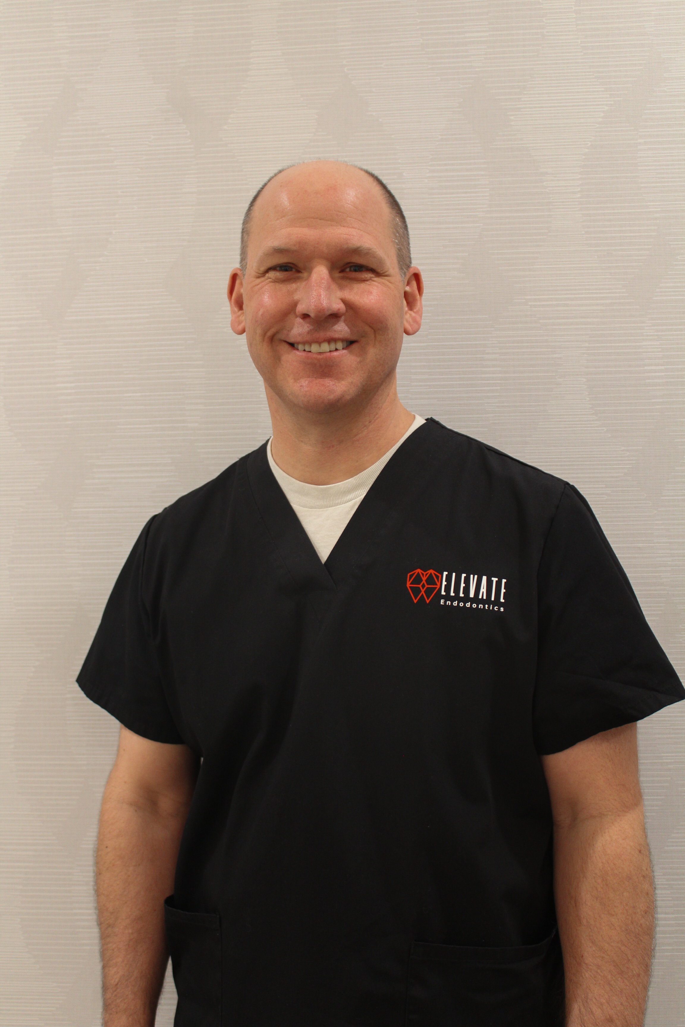 Dr. Richard Bauman, an endodontist, enjoying the outdoors with trees in the background.